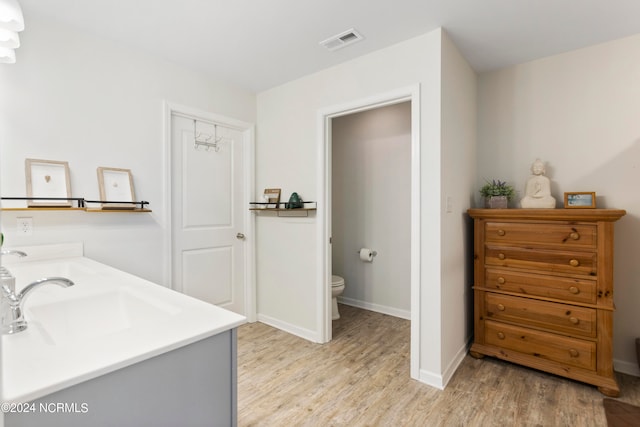 bathroom with hardwood / wood-style flooring, vanity, and toilet