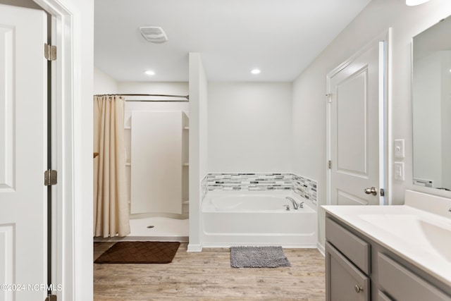 bathroom with vanity, plus walk in shower, and hardwood / wood-style floors