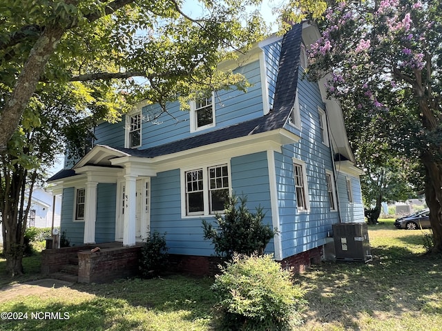 view of front of property featuring a shingled roof, covered porch, and central AC