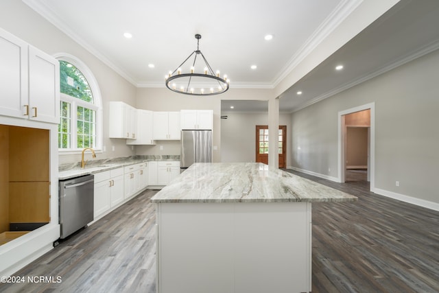 kitchen featuring a kitchen island, appliances with stainless steel finishes, pendant lighting, white cabinetry, and light stone counters