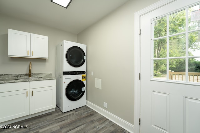 laundry area with stacked washer and dryer, sink, cabinets, and dark hardwood / wood-style floors