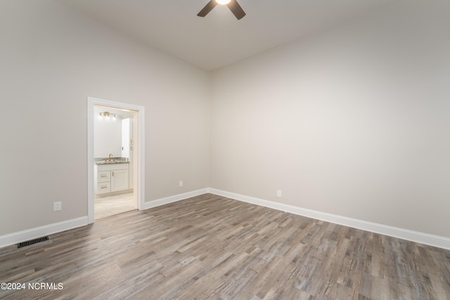 empty room with ceiling fan, lofted ceiling, and hardwood / wood-style floors