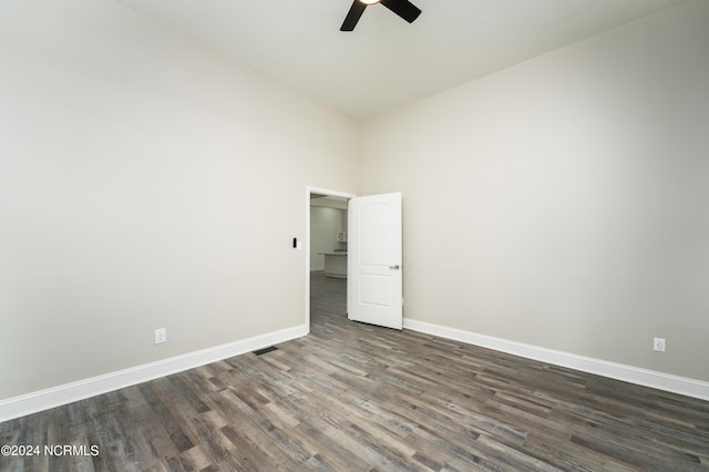 spare room with dark hardwood / wood-style flooring and ceiling fan