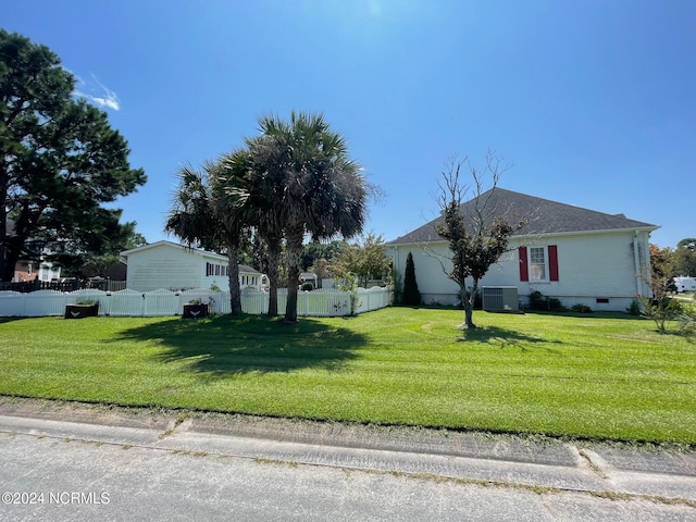 view of home's exterior with a yard and central AC