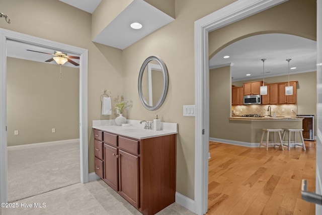 bathroom featuring vanity, ceiling fan, and tasteful backsplash