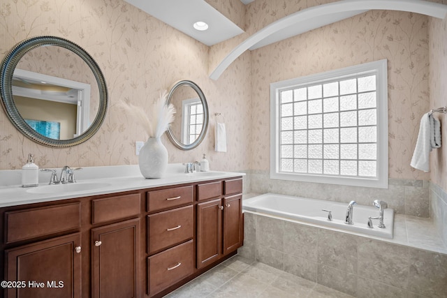 bathroom featuring tile patterned floors, vanity, and tiled tub