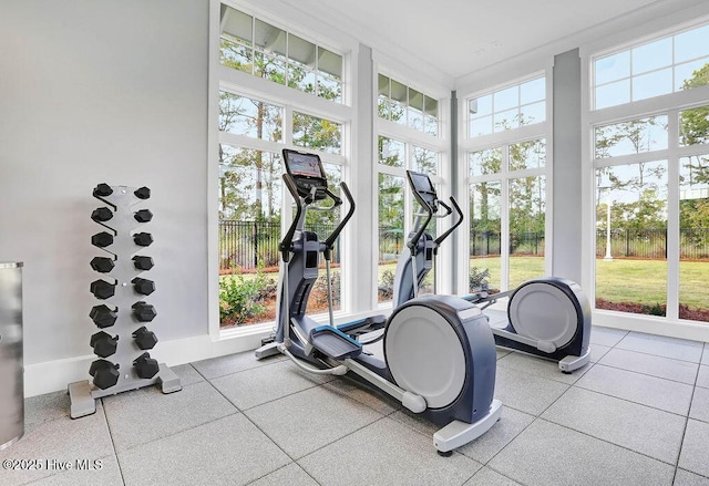 workout room featuring a towering ceiling and floor to ceiling windows