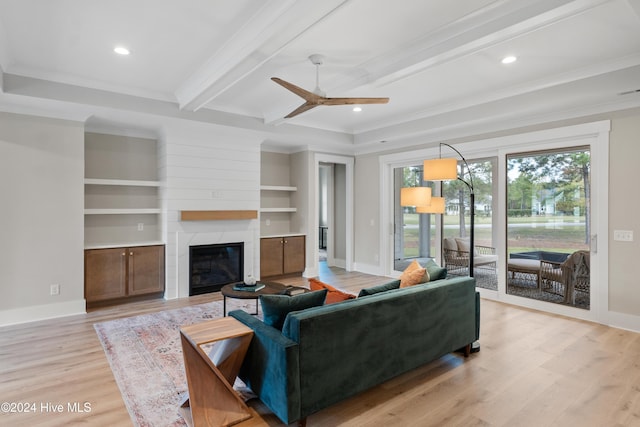 living area featuring light wood-style floors, beam ceiling, baseboards, and a premium fireplace