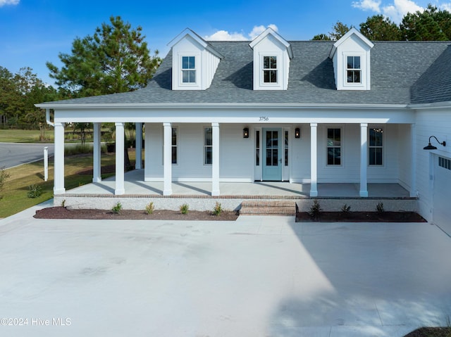 view of front facade with covered porch and roof with shingles