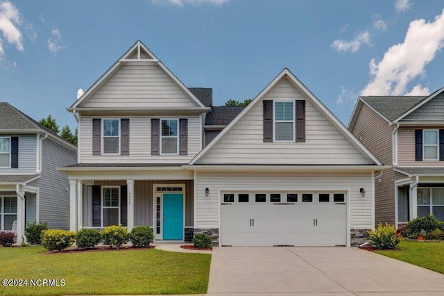 craftsman-style house featuring a porch, a front yard, and a garage