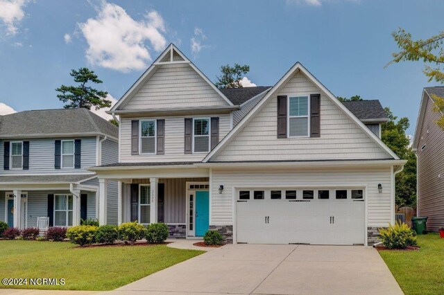 craftsman inspired home featuring a front yard and covered porch