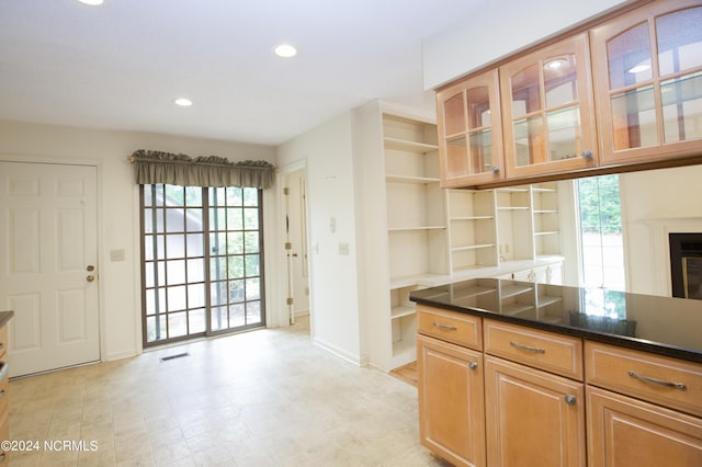 kitchen with open shelves, recessed lighting, visible vents, glass insert cabinets, and a glass covered fireplace