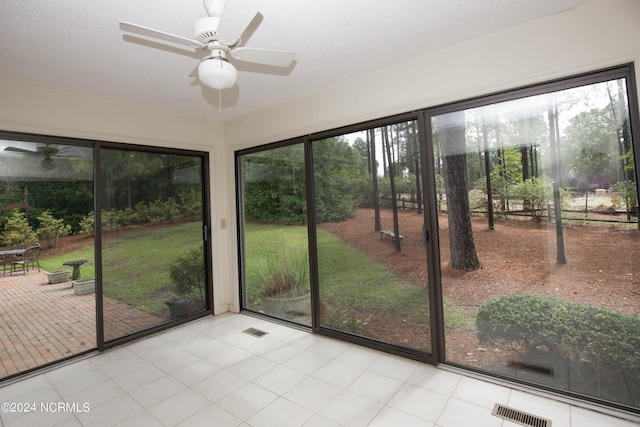 unfurnished sunroom featuring a ceiling fan and visible vents