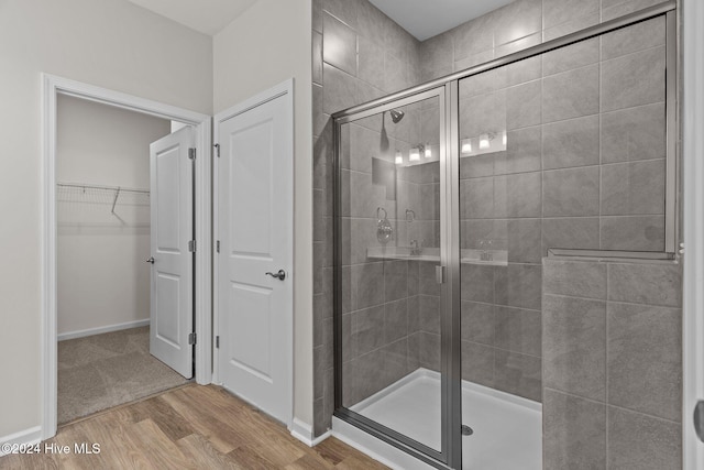 bathroom with hardwood / wood-style floors and walk in shower