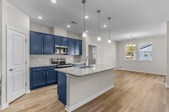 kitchen featuring blue cabinetry, appliances with stainless steel finishes, a center island with sink, and sink