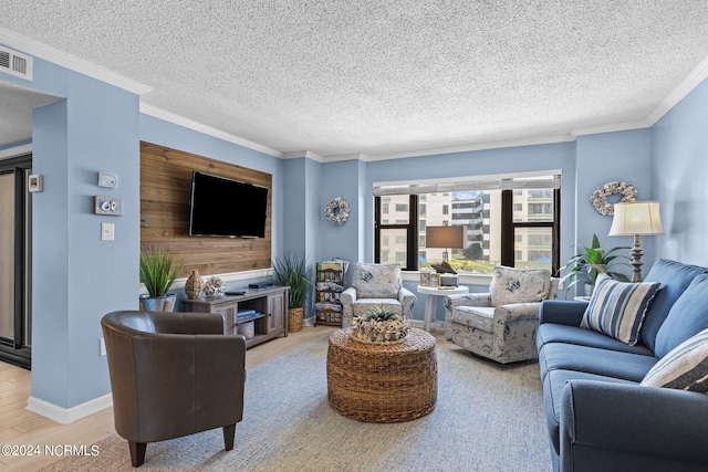 living room with a textured ceiling, light hardwood / wood-style flooring, and ornamental molding