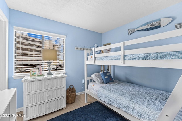 bedroom featuring light hardwood / wood-style flooring and a textured ceiling