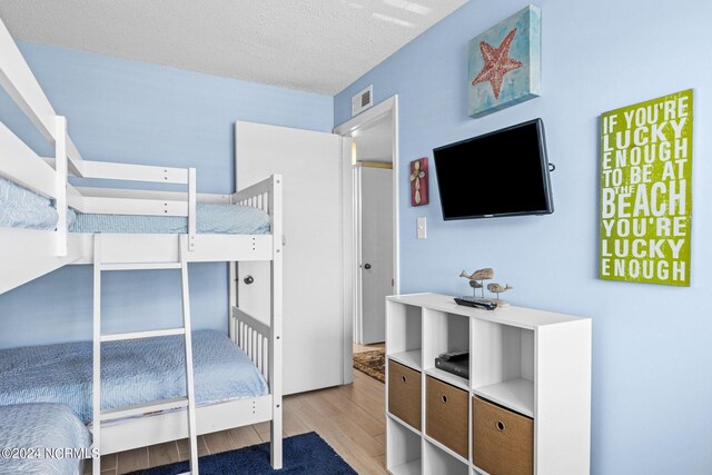 bedroom featuring a textured ceiling and light wood-type flooring