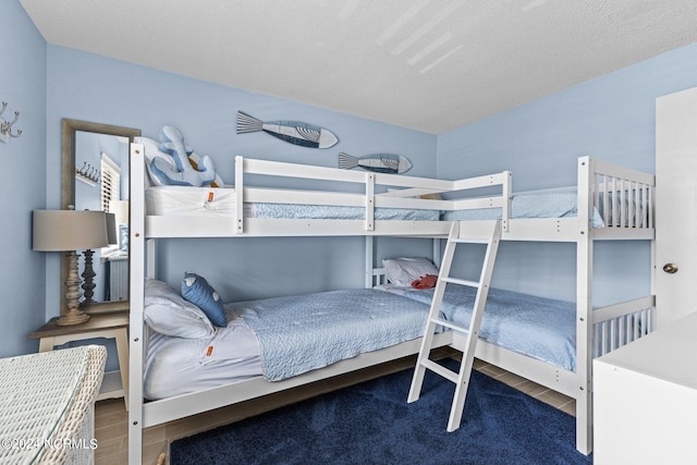 bedroom featuring a textured ceiling and wood-type flooring