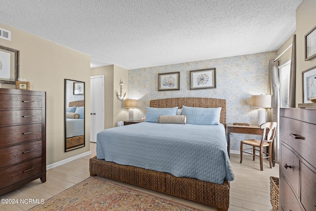 bedroom featuring light wood-type flooring and a textured ceiling