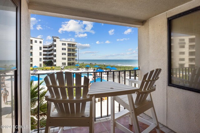 balcony with a water view and a community pool