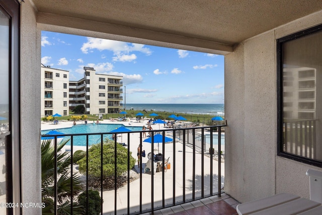 balcony with a water view and a community pool