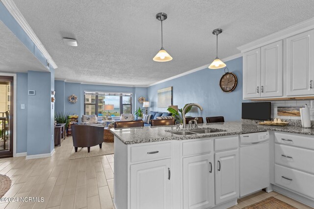 kitchen featuring white dishwasher, crown molding, and kitchen peninsula