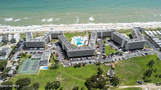 birds eye view of property with a water view and a beach view