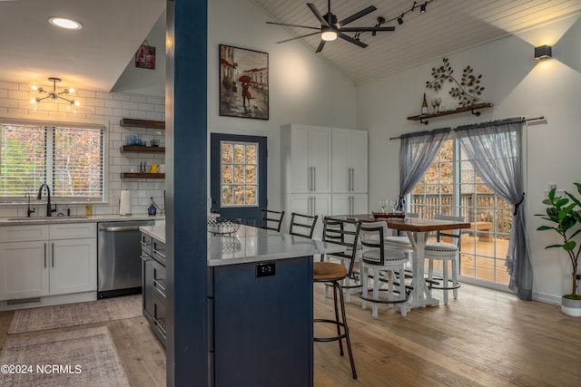 kitchen with dishwasher, a wealth of natural light, a breakfast bar area, and sink