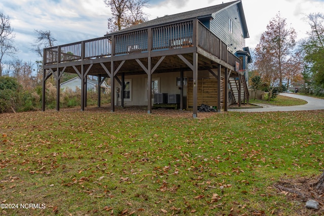 back of property featuring a lawn and a deck