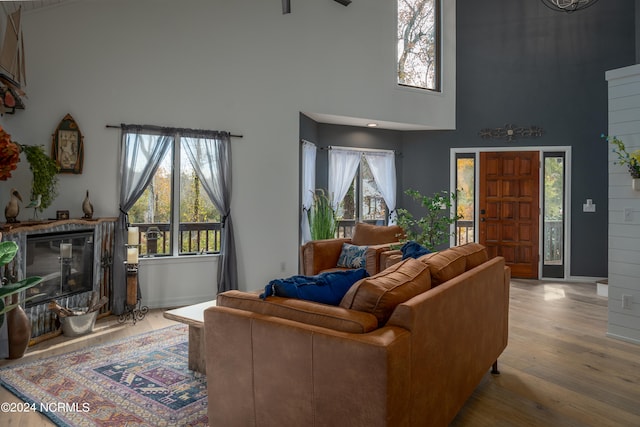 living room featuring wood-type flooring, plenty of natural light, and a towering ceiling