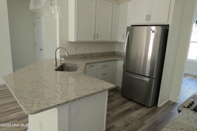 kitchen featuring white cabinets, sink, and stainless steel fridge