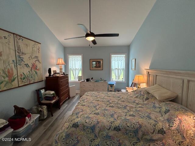 bedroom featuring hardwood / wood-style flooring, vaulted ceiling, and ceiling fan