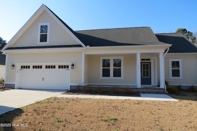 view of front of property with a garage, a front yard, and a porch