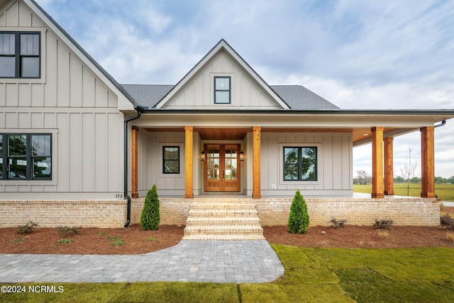 doorway to property with covered porch and french doors