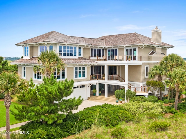 rear view of house with a balcony and a garage