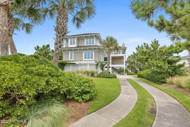 raised beach house with a balcony and a front yard