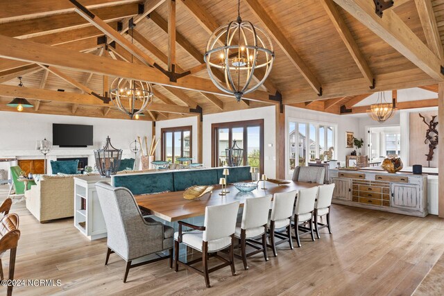 dining space with light hardwood / wood-style floors, an inviting chandelier, beamed ceiling, and wood ceiling