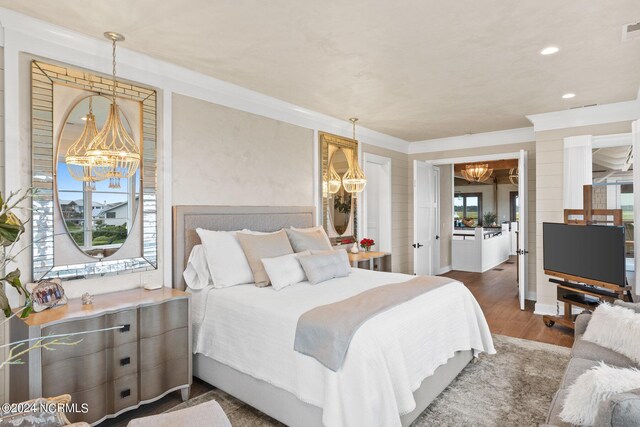 bedroom with ornamental molding, an inviting chandelier, and dark wood-type flooring