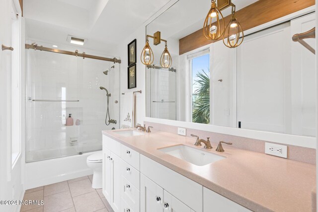 full bathroom with tiled shower / bath combo, toilet, tile patterned flooring, and double sink vanity