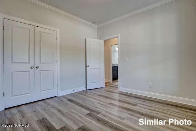 unfurnished bedroom with light wood finished floors, baseboards, a closet, and ornamental molding