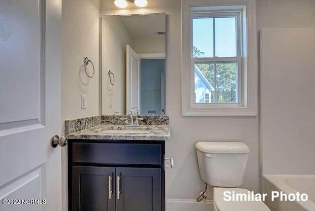 full bathroom featuring a tub to relax in, vanity, and toilet