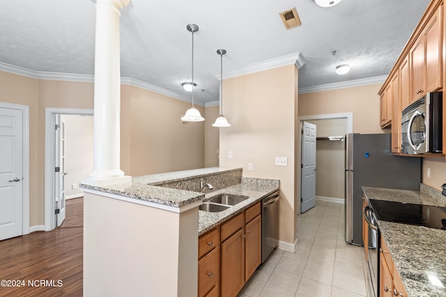 kitchen featuring appliances with stainless steel finishes, decorative columns, sink, light tile patterned flooring, and ornamental molding