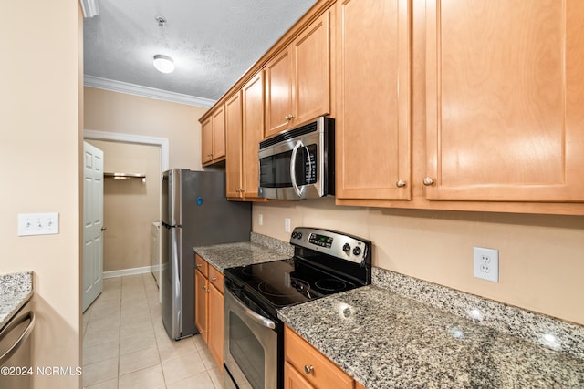 kitchen with dark stone counters, light tile patterned flooring, stainless steel appliances, ornamental molding, and a textured ceiling