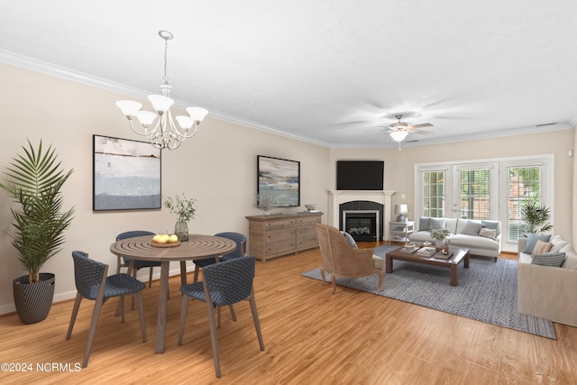 dining space featuring ceiling fan with notable chandelier, crown molding, and light wood-type flooring