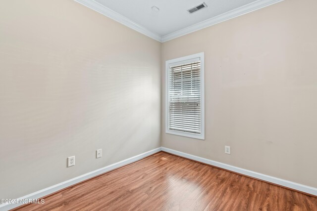 unfurnished room with wood-type flooring, crown molding, and plenty of natural light