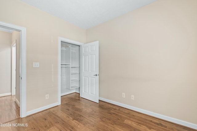 unfurnished bedroom with a closet and hardwood / wood-style flooring