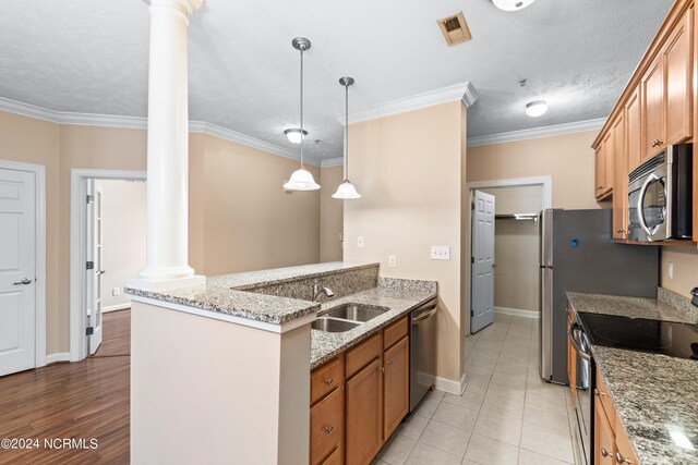 kitchen with light tile patterned flooring, decorative columns, stainless steel appliances, sink, and ornamental molding