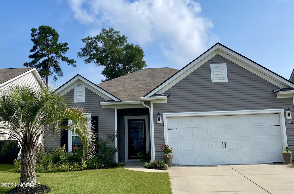 view of front of home featuring a garage and a front lawn