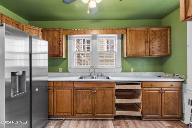 kitchen featuring sink, ceiling fan, light hardwood / wood-style floors, and stainless steel refrigerator with ice dispenser